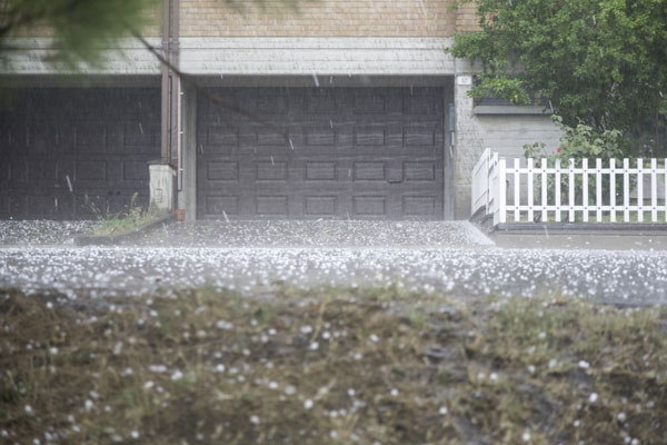 home garage and driveway during hail storm in Texas causing roof damage